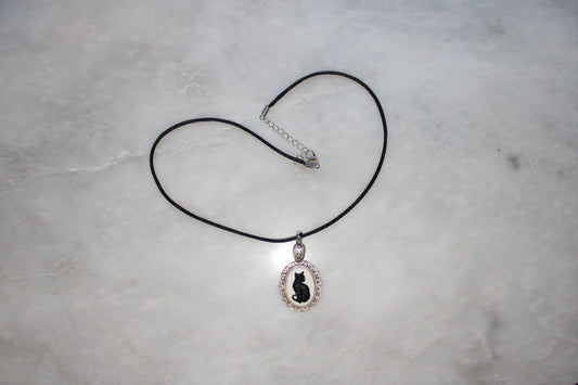 Necklace with a pendant featuring a cat design on a gray surface